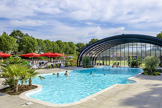 Piscine extérieure et couverte avec baigneurs au camping CAPFUN IJsselstrand à Doesburg.