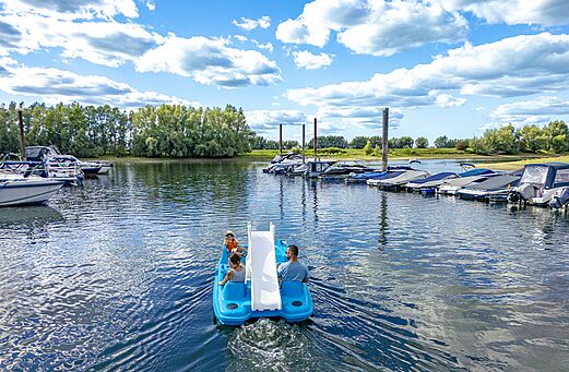 Pédalo avec toboggan et famille sur l'eau au camping CAPFUN IJsselstrand à Doesburg.