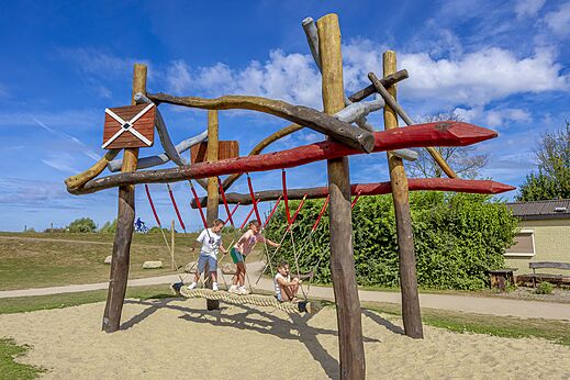 Aire de jeux en bois avec enfants sur pont de cordes au camping CAPFUN IJsselstrand à Doesburg.
