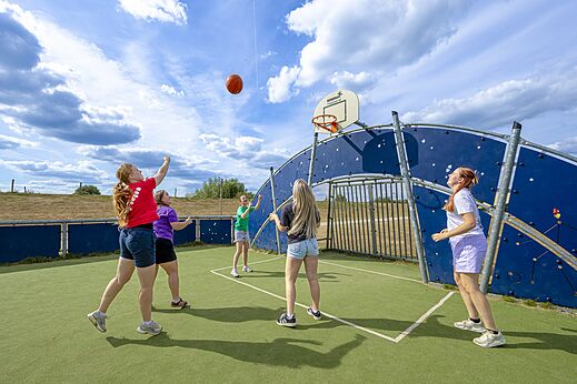 Terrain multisport et jeunes jouant au basketball au camping CAPFUN IJsselstrand à Doesburg.