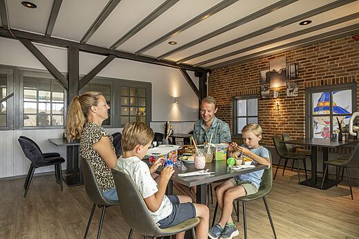 Famille dînant au restaurant du camping CAPFUN IJsselstrand à Doesburg.