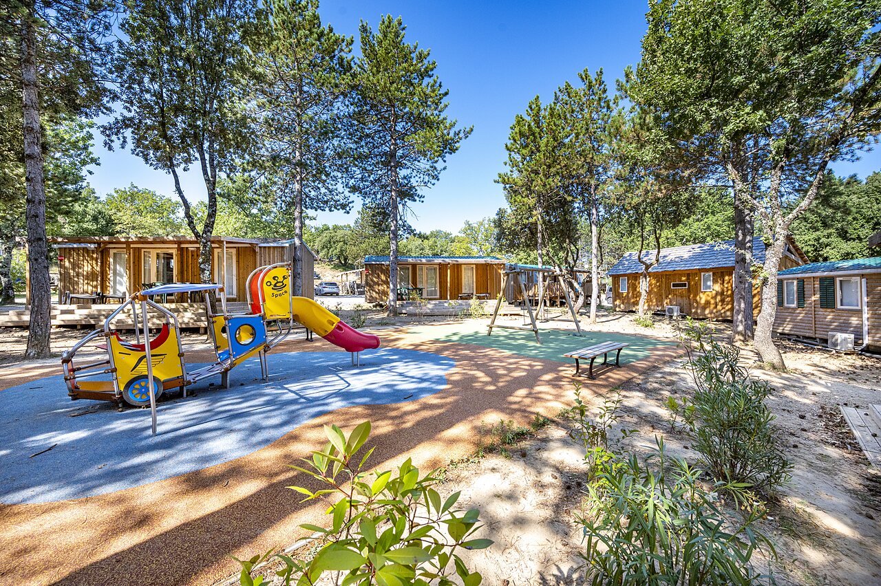 Aire de jeux color�e avec toboggan et balan�oires, mobile-homes au camping CAPFUN Imbours � LARNAS (07).