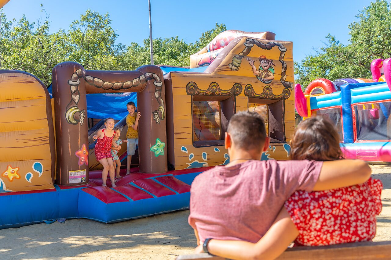 Aire de jeux gonflable pirate avec enfants souriants au camping CAPFUN Imbours � LARNAS (07).
