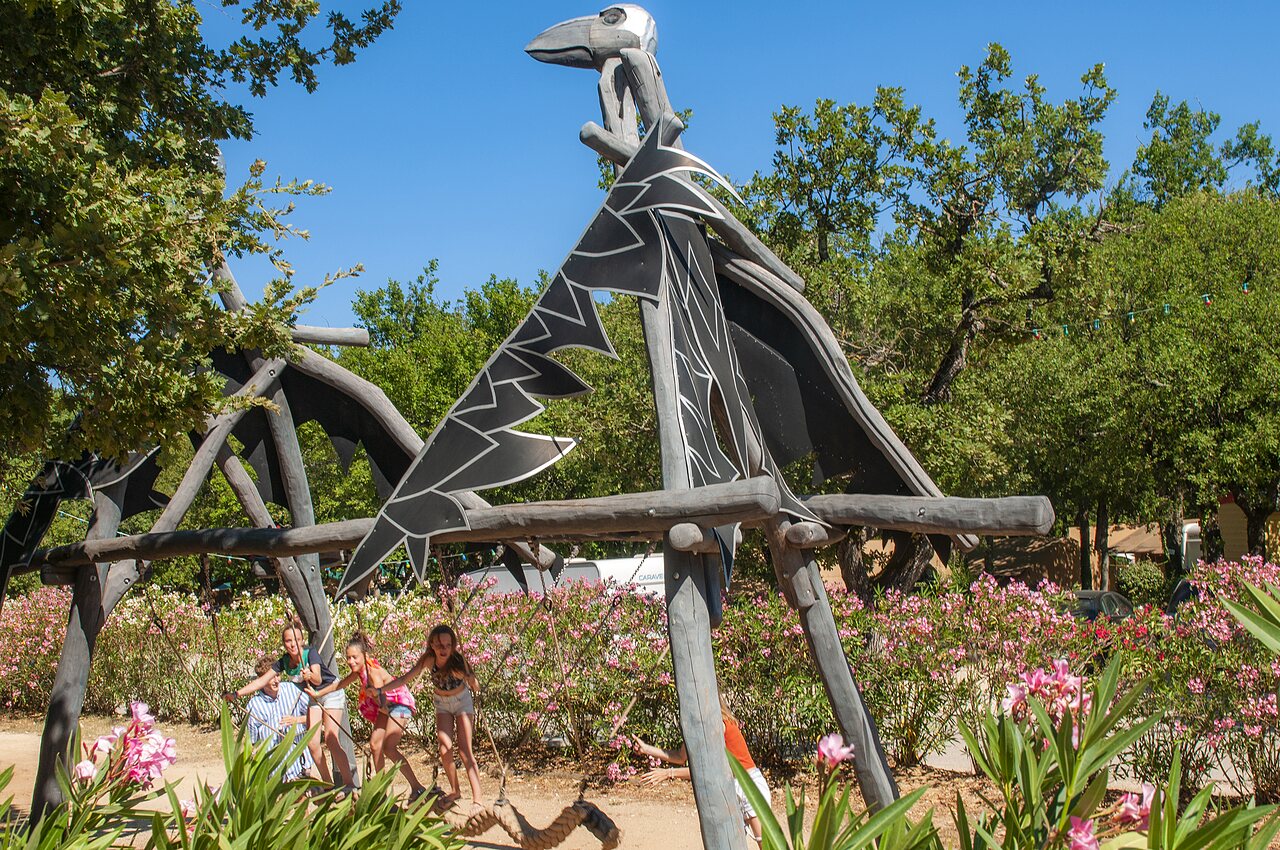 Structure de jeux dragon avec enfants sur balan�oires au camping CAPFUN Imbours � LARNAS (07).