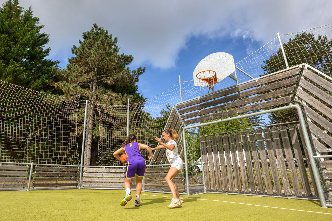 Jeunes femmes jouant basketball sur terrain multisport au camping CLICOCHIC Lac de Miel.