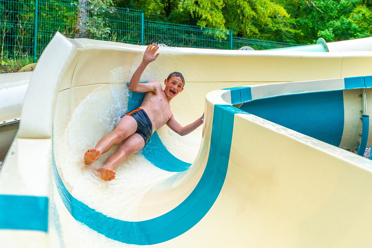 Toboggan aquatique avec un enfant souriant au camping VAGUES OCEANES Lac de Panthier � Vandenesse-en-Auxois (21).