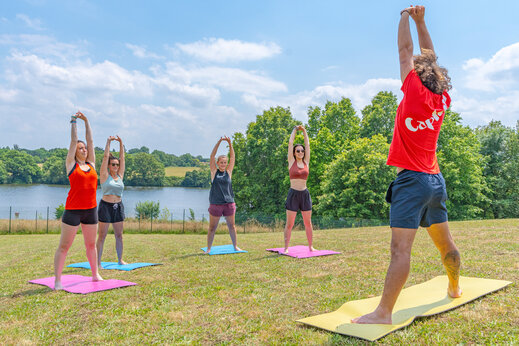 Séance de stretching en groupe sur tapis au camping CAPFUN Lac de Ribou à Cholet (49).