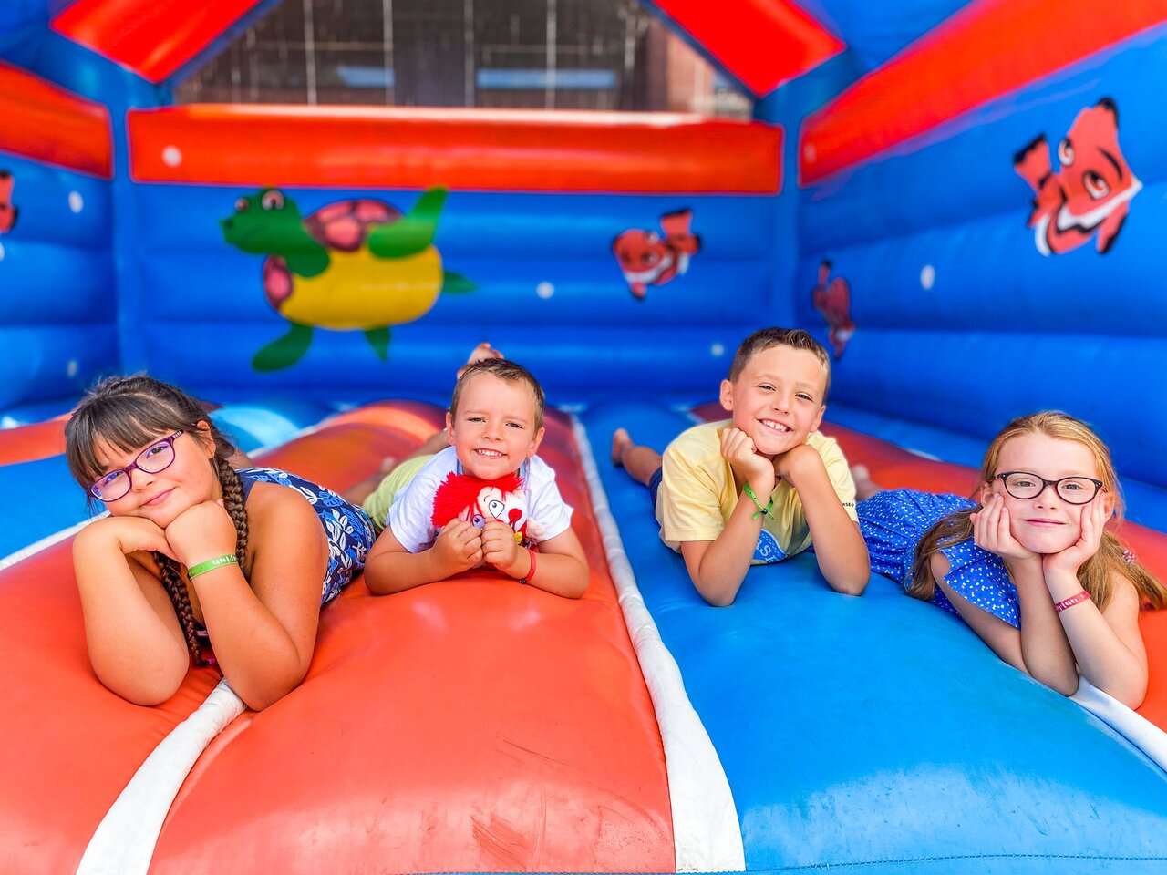 Quatre enfants souriants sur un ch�teau gonflable color� au camping CAPFUN Landisland � Moliets-et-Maa.