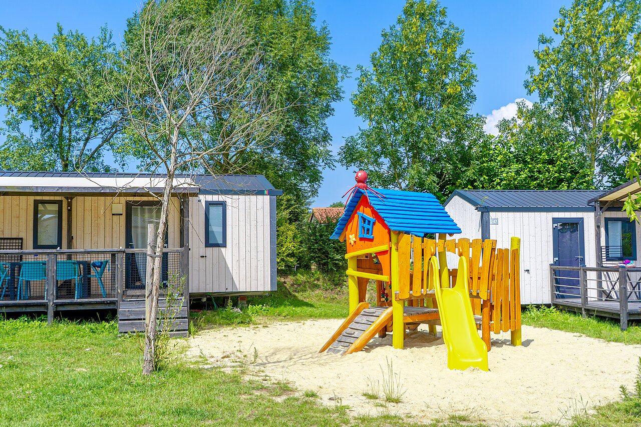 Aire de jeux, toboggan et Mobil-homes au camping VAGUES OCEANES Les Iles � Hudimesnil.