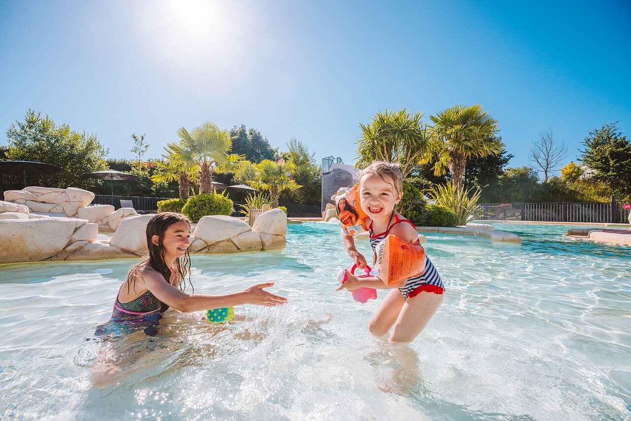 Piscine, enfants souriants, toboggan au camping VAGUES OCEANES Les Iles � Hudimesnil.