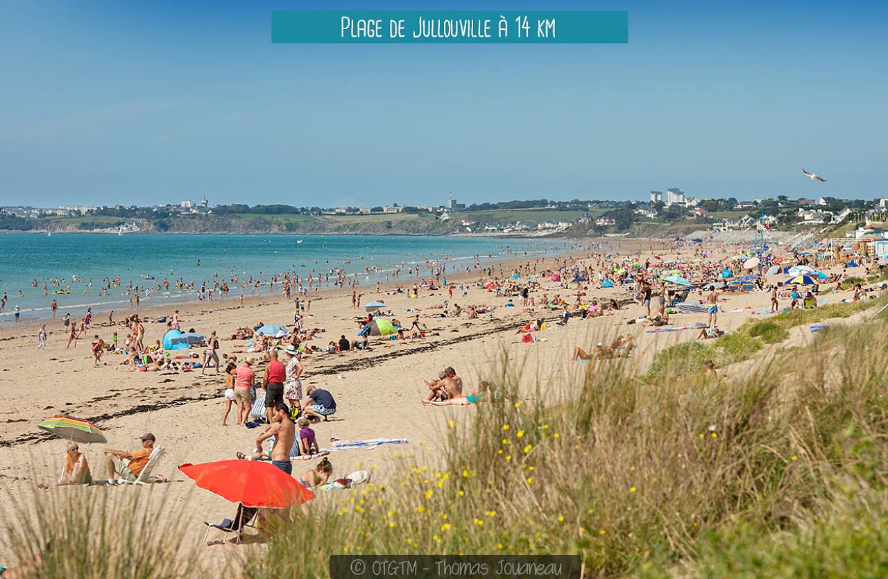 Plage de Jullouville, Normandie, avec baigneurs et sable fin.