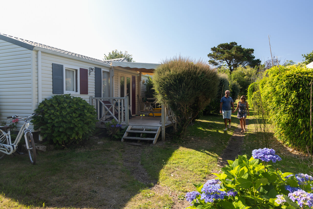 Mobile home, couple dans jardin au camping CLICOCHIC � Lannion (22).