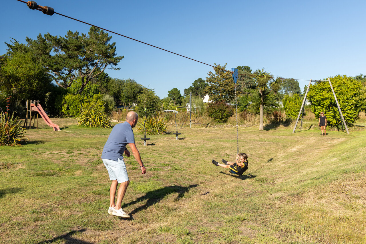 Enfant sur tyrolienne, aire de jeux au camping CLICOCHIC Les plages de Beg L�guer � Lannion (22).