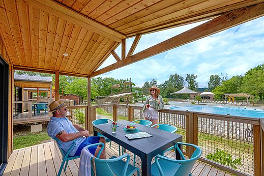 Terrasse de Mobil-home avec vue sur la piscine et toboggans au camping CLICOCHIC Les Secrets de Padirac � Padirac (46).