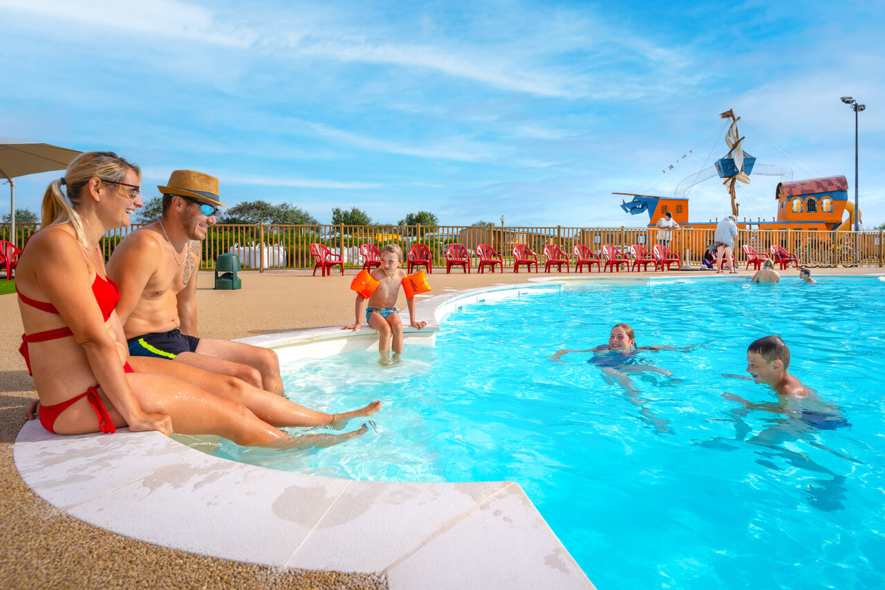 Famille profitant de la piscine avec jeux aquatiques au camping VAGUES OCEANES Licorne � Dunkerque (59).
