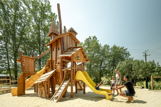 Grande aire de jeux en bois avec toboggans au camping CLICOCHIC Linotte.