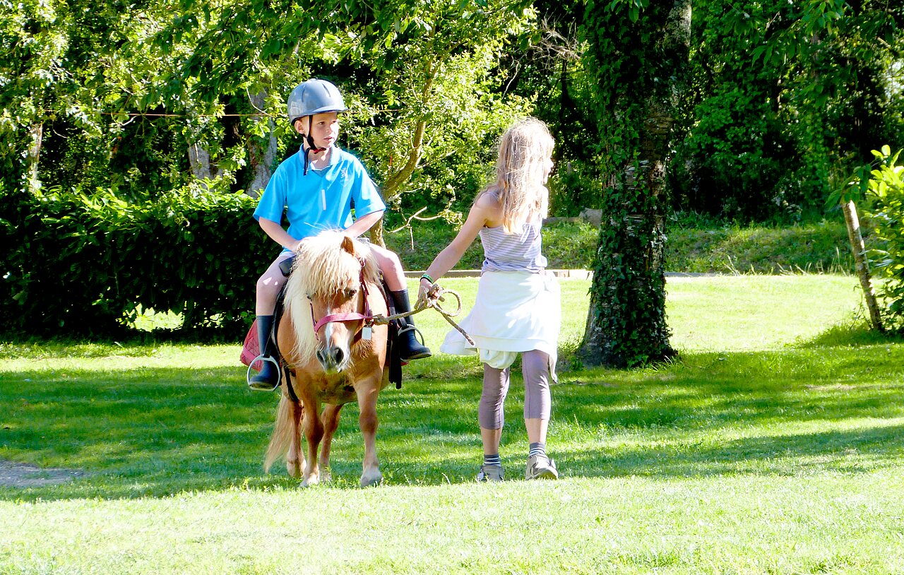 Enfant � poney, encadr� par une animatrice au camping CAPFUN Lodge � SARZEAU (56)
