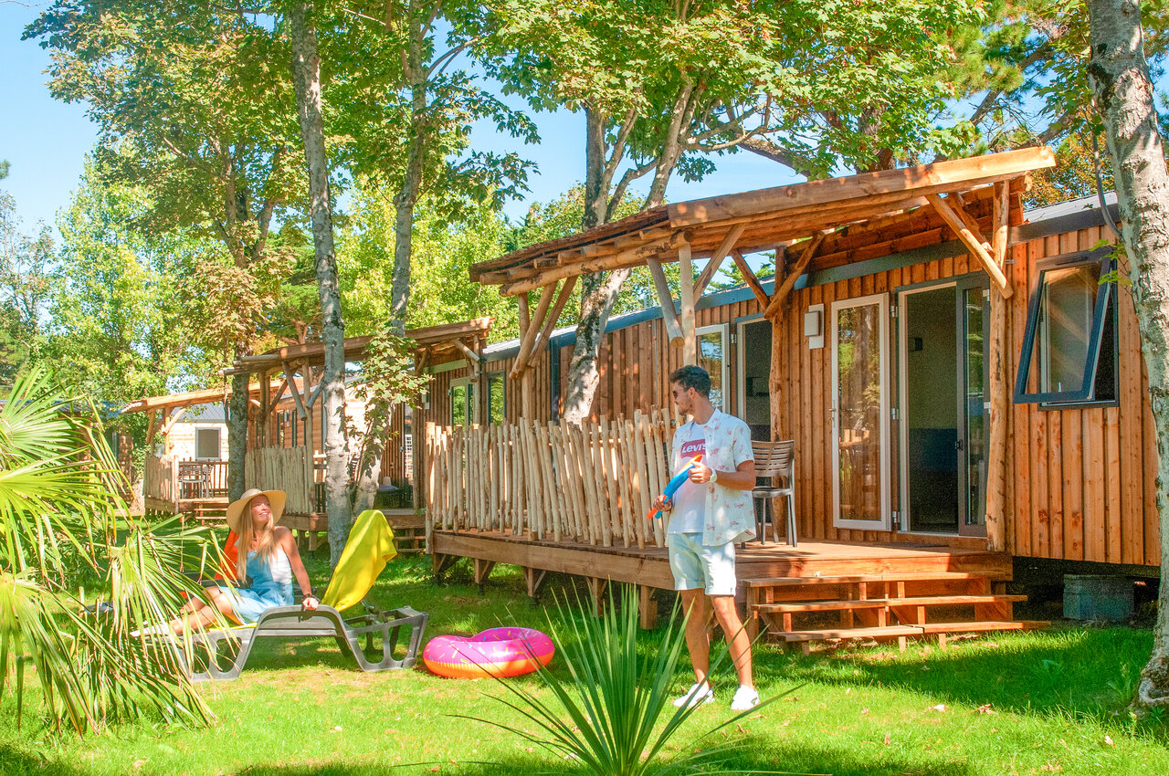 Mobile homes en bois avec terrasse, couple se d�tendant au camping CAPFUN Loubine � Les Sables d'Olonne (85).