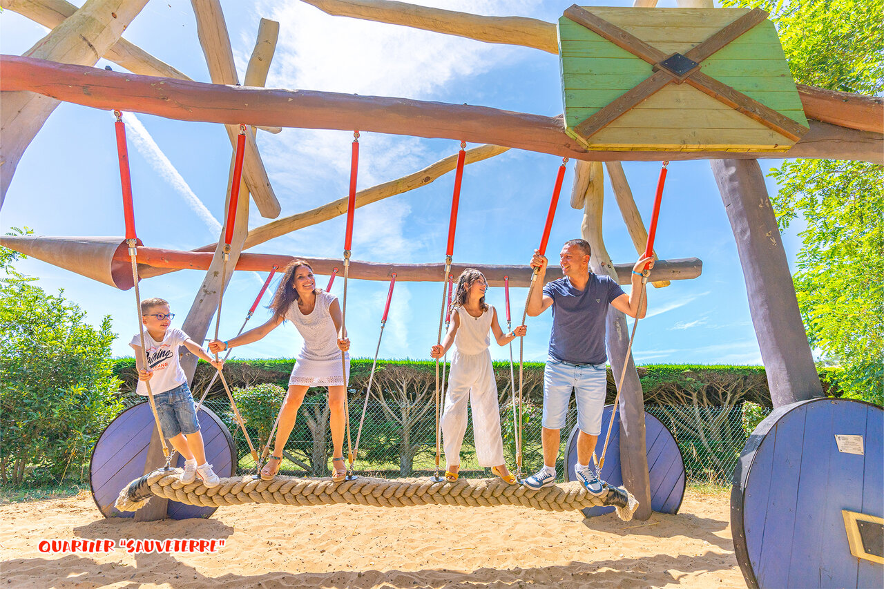 Famille s'amusant sur une structure de jeux en bois au camping CAPFUN Loubine � Les Sables d'Olonne.