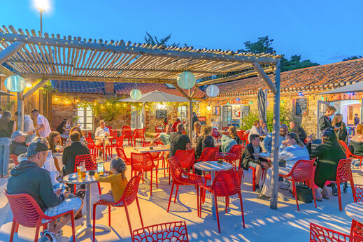 Terrasse de restaurant extérieure animée avec convives au camping CAPFUN Loubine à Les Sables d'Olonne (85).