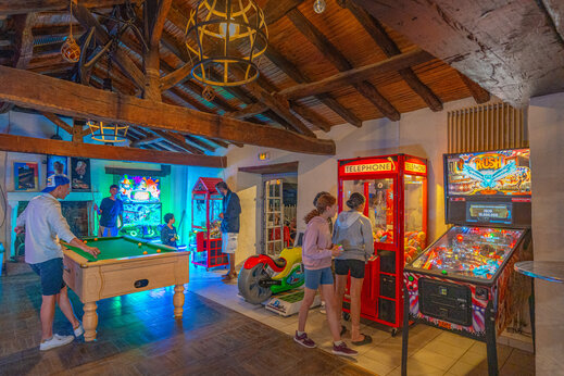 Salle de jeux avec billard et bornes d'arcade au camping CAPFUN Loubine.