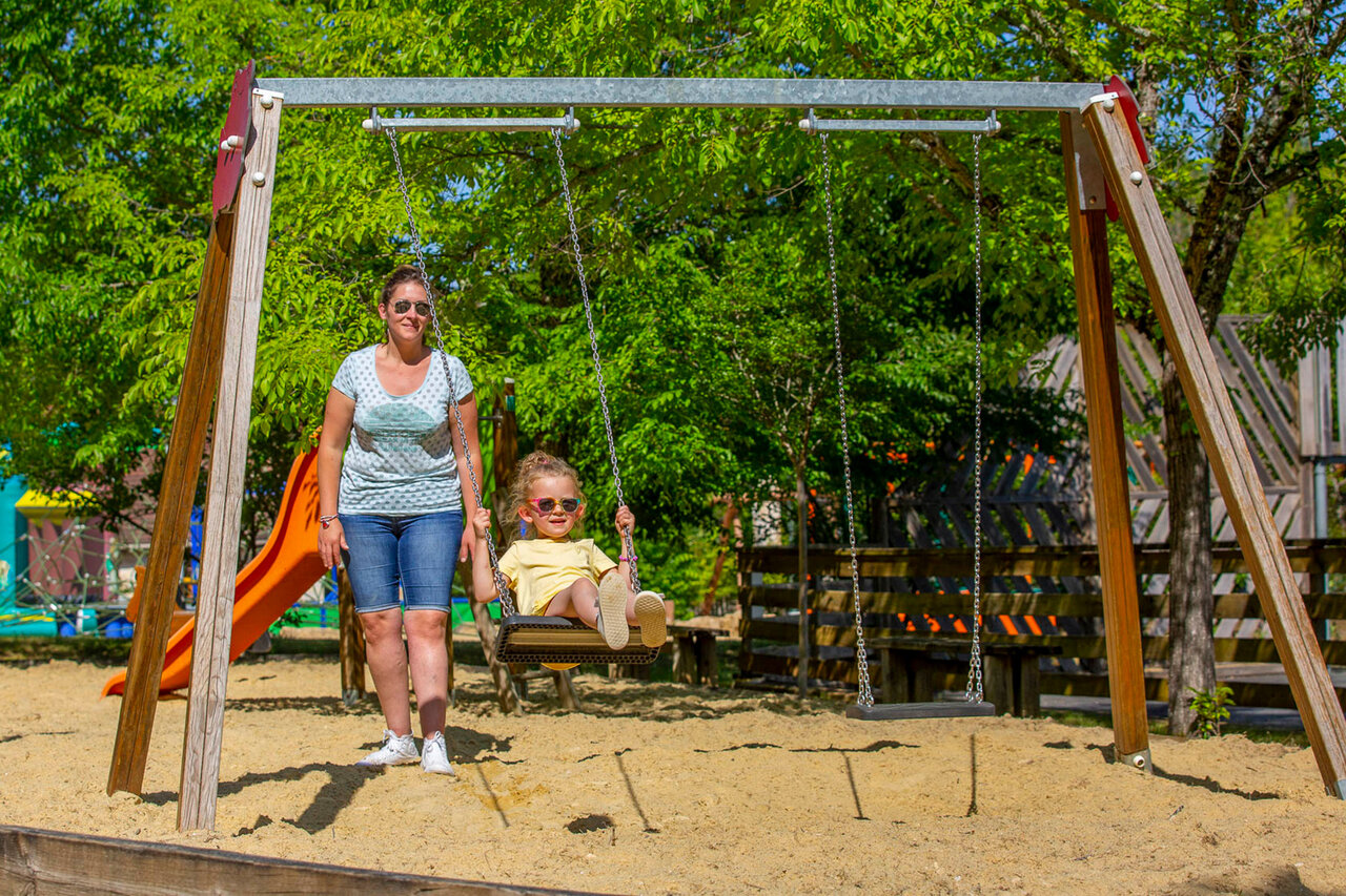 Enfant sur balan�oire, aire de jeux au camping CLICOCHIC Lou Castel � Castelnaud-la-Chapelle (24).