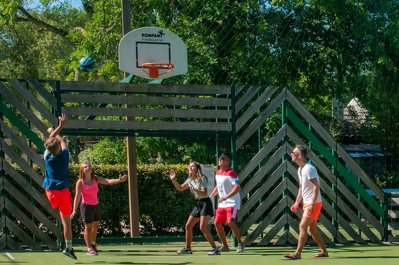 Famille jouant au basketball sur le terrain multisport au camping CAPFUN Lou Puntaou � LEON (40).