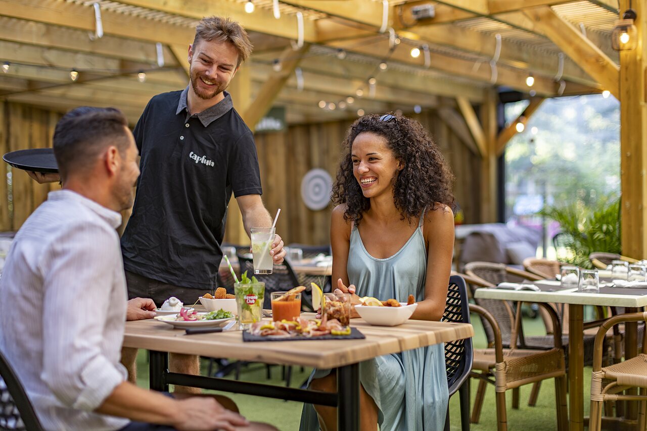 Couple d�nant en terrasse, serveur souriant au CAPFUN Lou Puntaou � LEON.