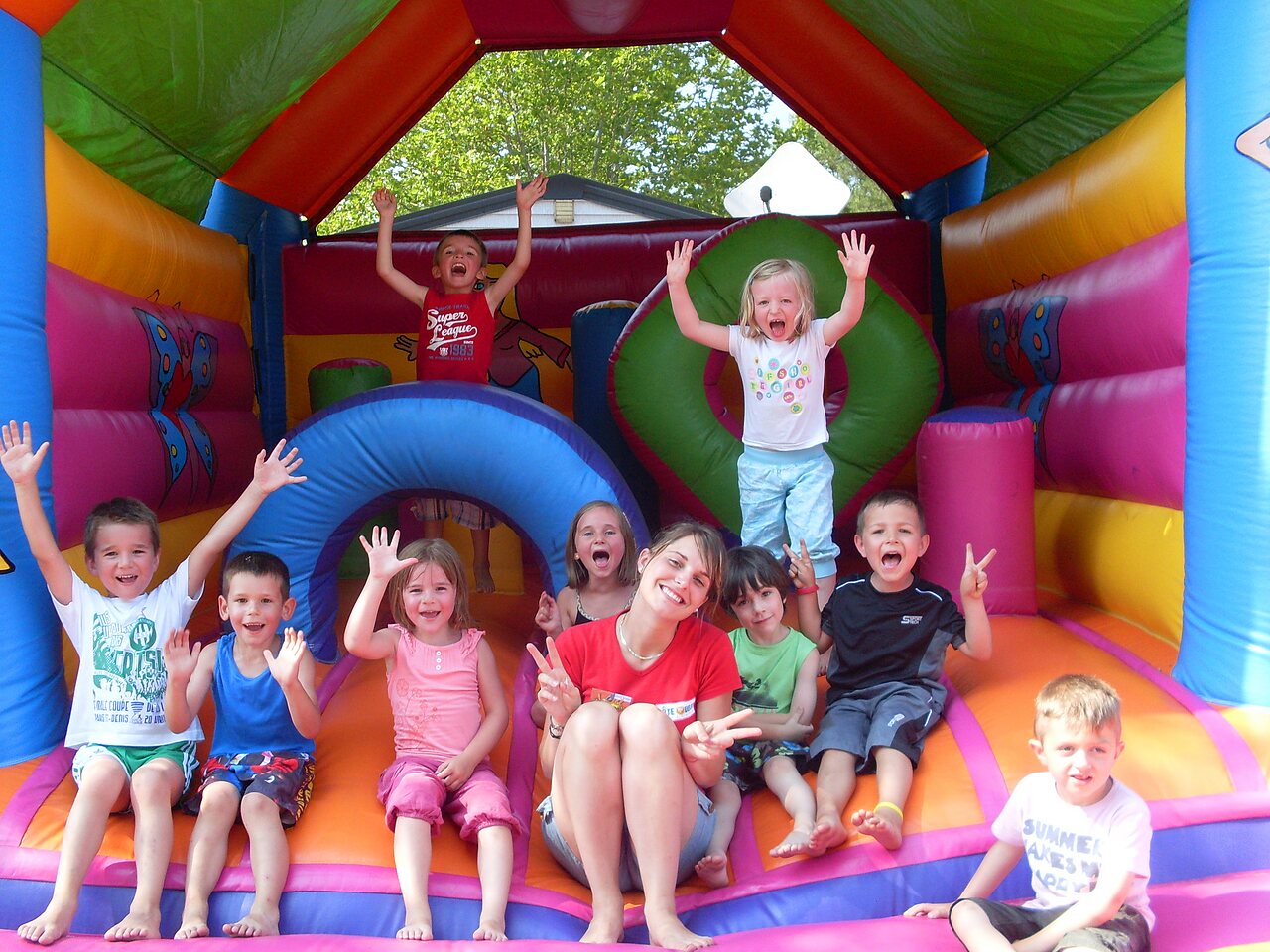 Enfants joyeux jouant dans un ch�teau gonflable color� au camping CAPFUN Lou Puntaou � LEON (40).
