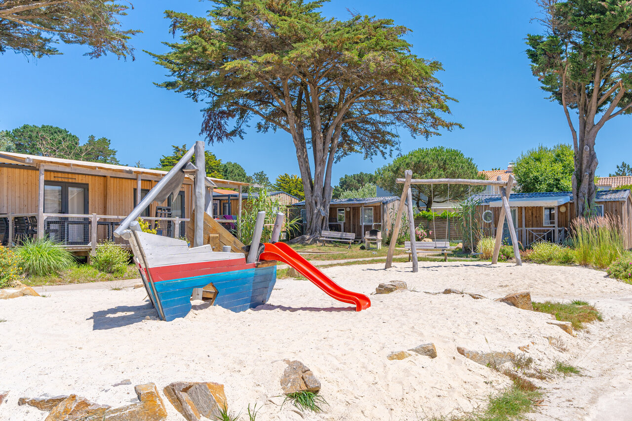 Aire de jeux sable avec bateau, toboggan et balan�oire au camping CAPFUN Madrague � PORNIC.