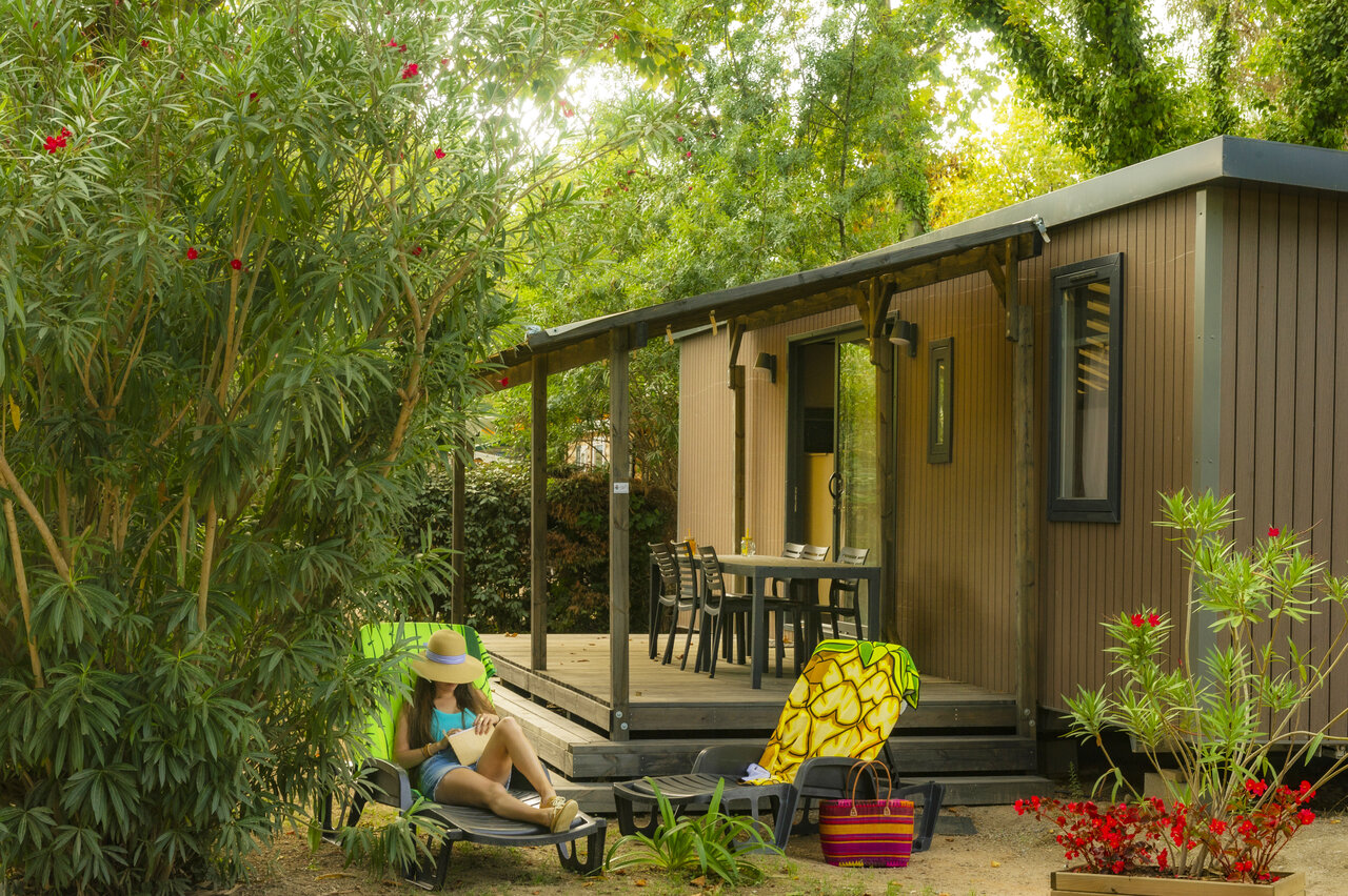 Mobil-home moderne avec terrasse et femme relaxant au camping CAPFUN Mael � ARGELES SUR MER (66).