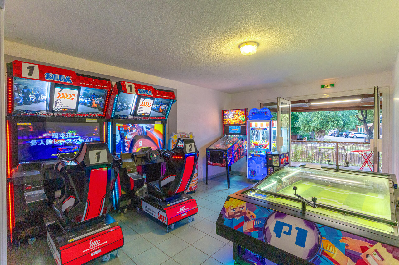 Salle de jeux avec simulateurs de course, flipper et baby-foot au camping CAPFUN Mael � ARGELES SUR MER (66).
