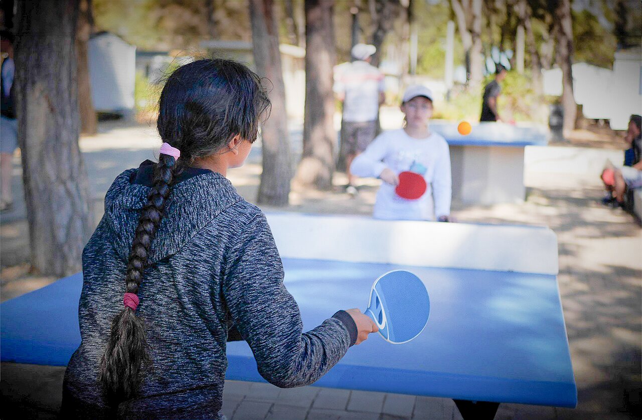 Enfants jouant au tennis de table ext�rieur au camping VAGUES OCEANES Manoir de Balkos.