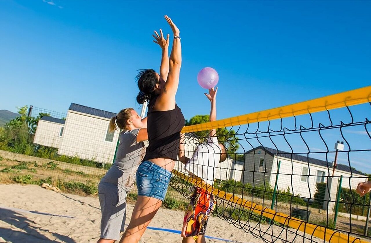 Joueurs de beach-volley sur terrain de sable au camping VAGUES OCEANES Manoir de Balkos � Valras-Plage (34).
