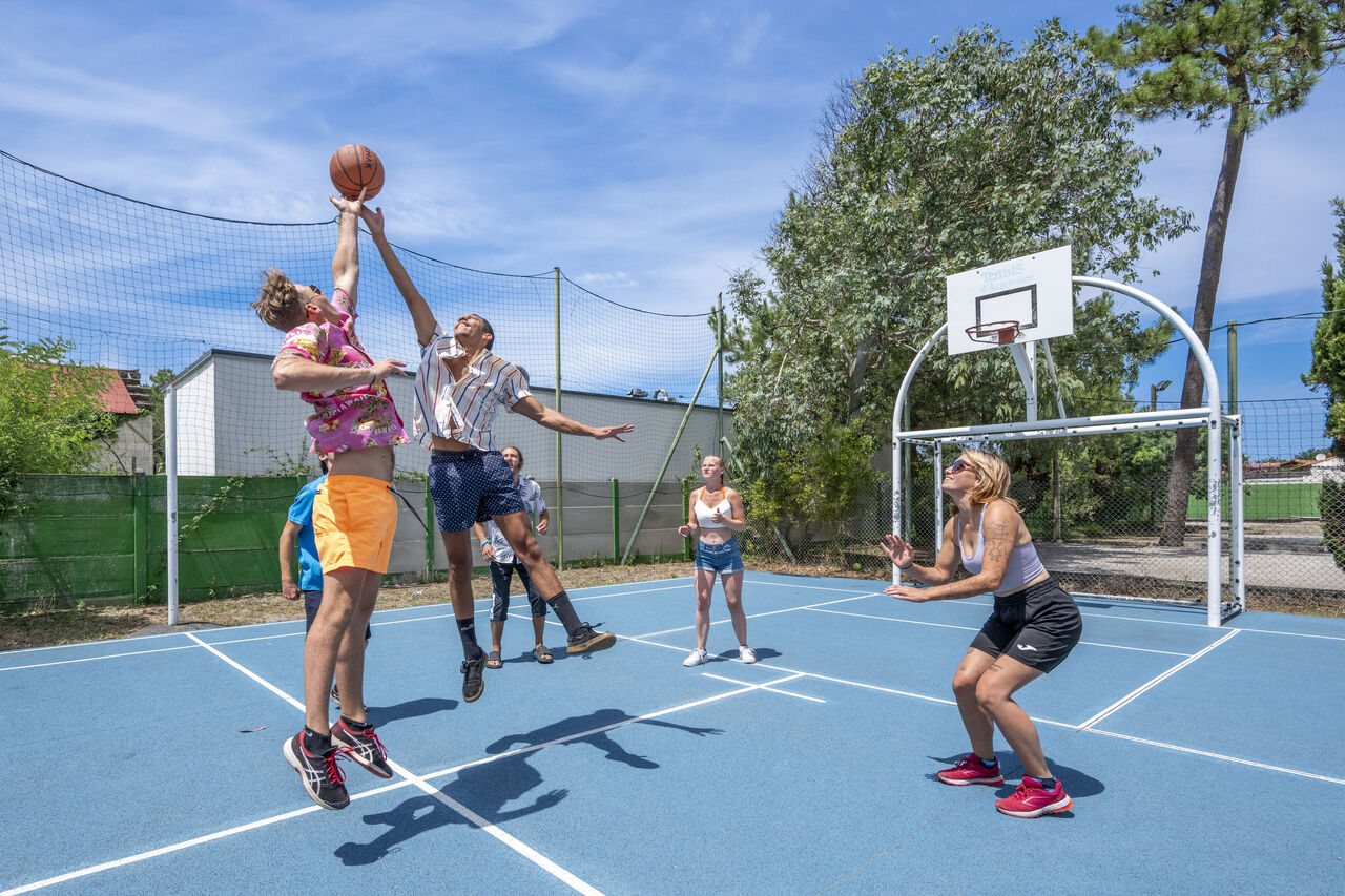 Joueurs de basketball sur terrain multisport au camping VAGUES OCEANES Marina Landes � Mimizan (40).