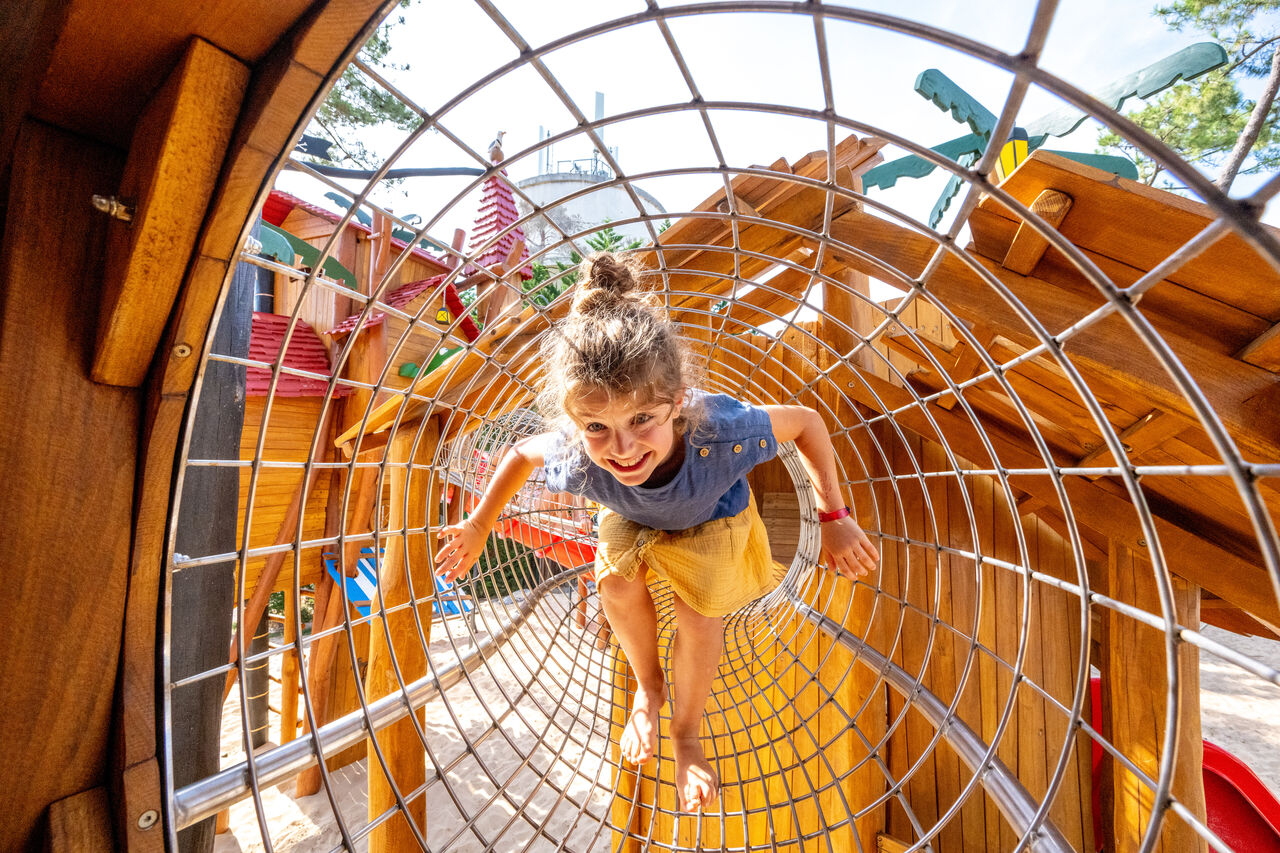 Enfant souriant dans tunnel de jeu au camping VAGUES OCEANES Marina Landes � Mimizan.