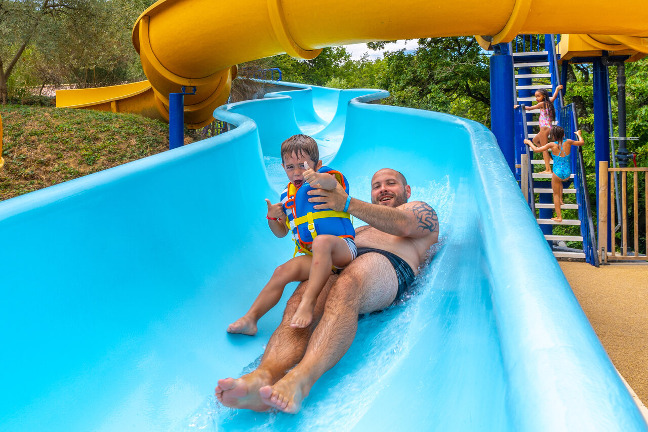 P�re et enfant sur toboggan aquatique g�ant au camping CAPFUN Merle Roux � Baix (07).