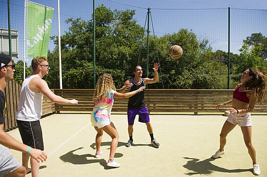 Jeunes jouant au basketball sur un terrain multisport au camping CAPFUN Mer et Soleil à Cap d'Agde (34).