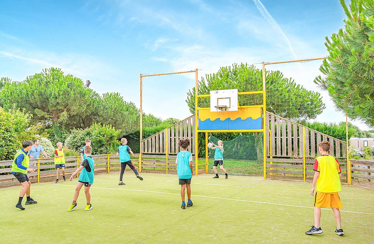 Enfants jouant au basket sur terrain multisport au camping VAGUES OCEANES � Givrand.