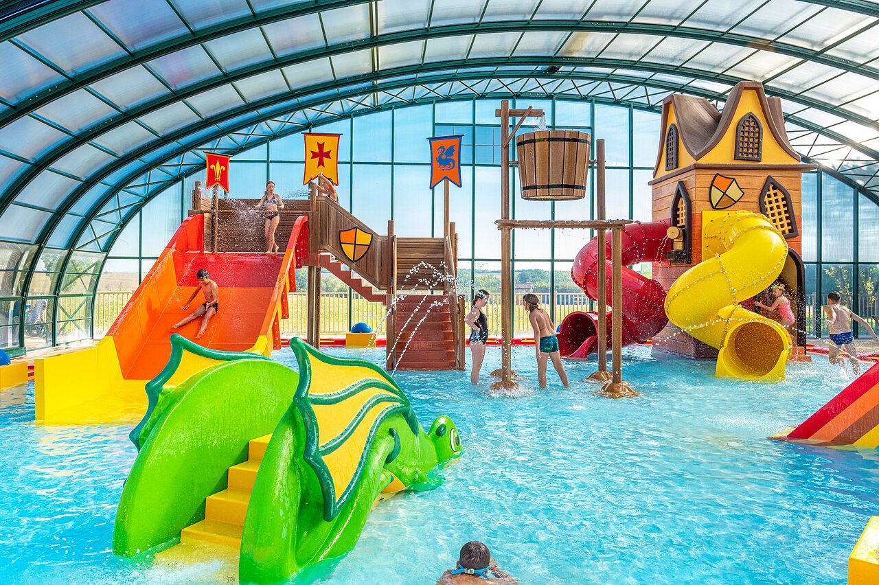 Piscine couverte avec toboggans, jeux d'eau et enfants au camping CAPFUN Mirabelle � VOLSTROFF (57).