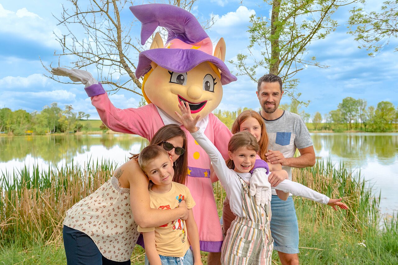 Mascotte et famille souriante pr�s du lac au camping CAPFUN Mirabelle � VOLSTROFF (57).