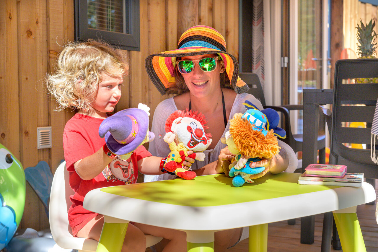 Enfant et femme jouent marionnettes au Mobil-home camping CAPFUN Mirmanda � Cambrils.