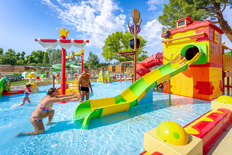 Espace aquatique avec toboggans et jeux d'eau pour enfants au camping VAGUES OCEANES Monte Cristo � Vauvert (30).