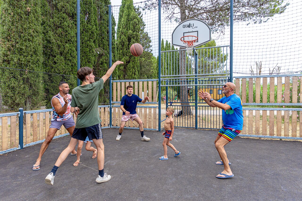Terrain de basketball avec famille jouant, ambiance conviviale au camping VAGUES OCEANES Monte Cristo � Vauvert (30).