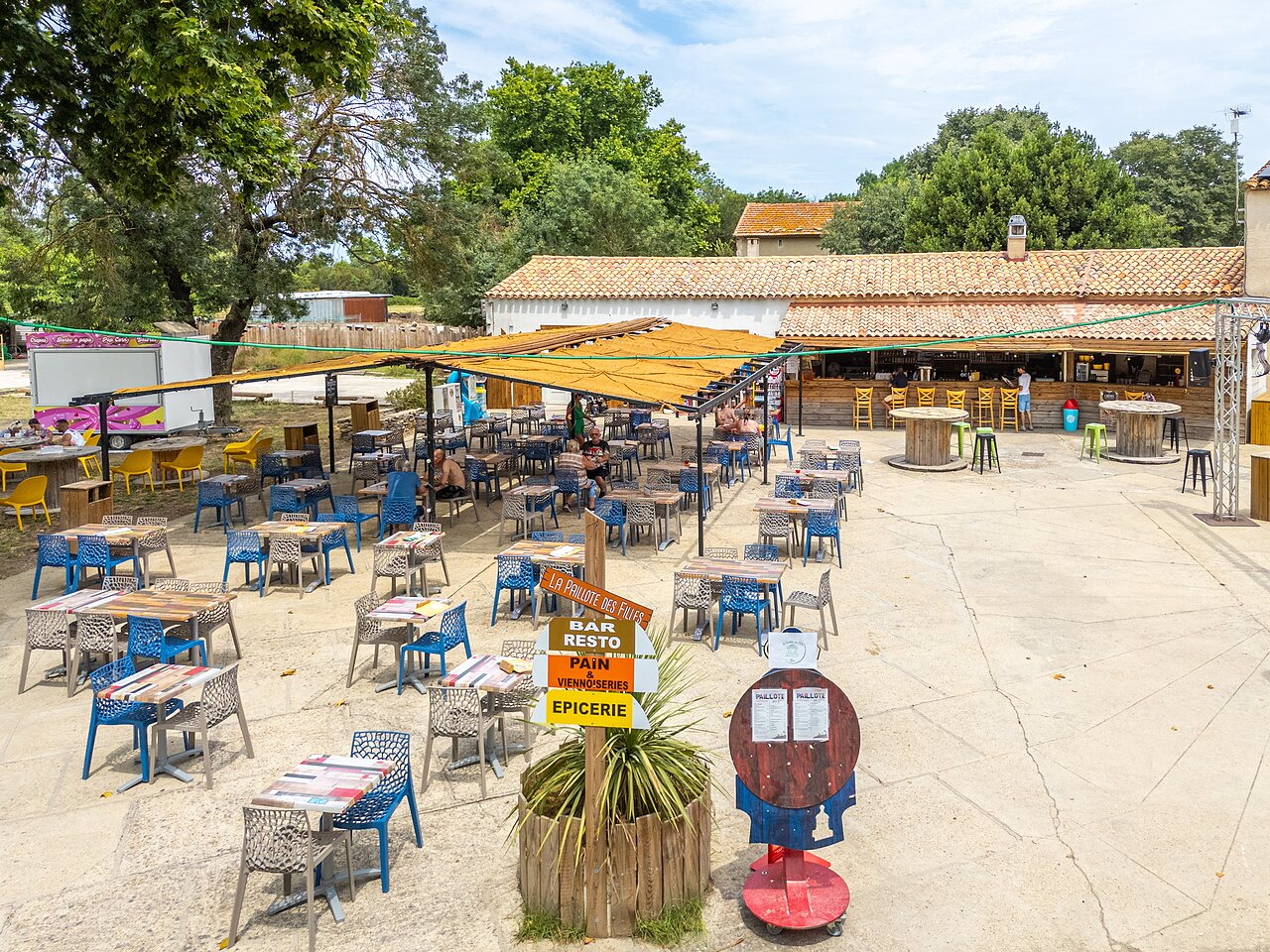 Terrasse ext�rieure du restaurant, bar et �picerie au camping VAGUES OCEANES Monte Cristo � Vauvert (30).