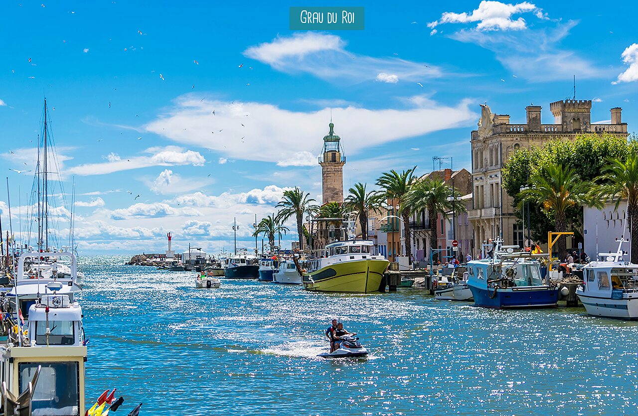Port anim� du Grau du Roi avec bateaux, jet ski et phare, Occitanie.