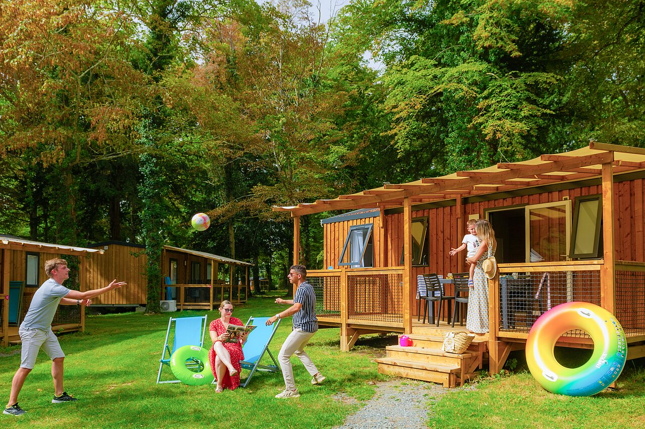 Famille jouant devant un Mobil-home moderne au camping CAPFUN Montsabert � COUTURES (49).