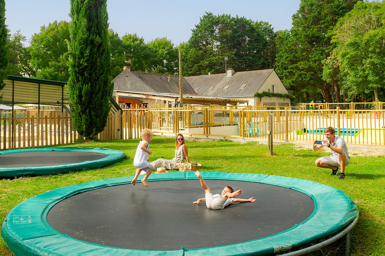 Enfants s'amusant sur trampolines, piscine proche, camping CAPFUN Montsabert, COUTURES (49).