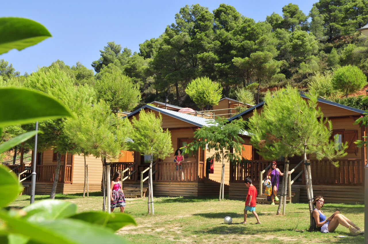 Mobil-homes en bois, vacanciers se d�tendant au camping CAPFUN Montblanc Park � Montblanc.