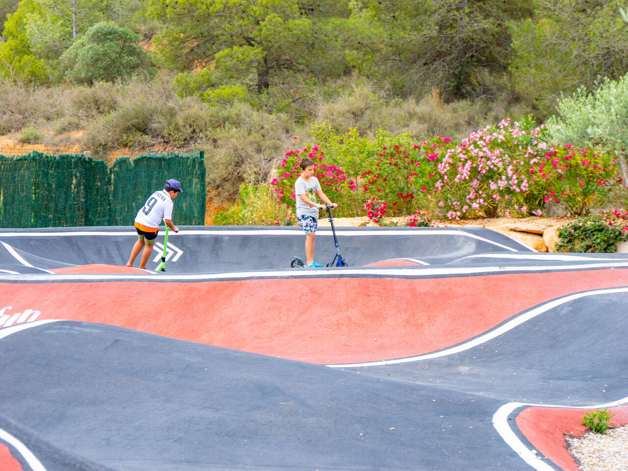 Piste de pump track avec enfants en trottinette au camping CAPFUN Montblanc Park � Montblanc (43).